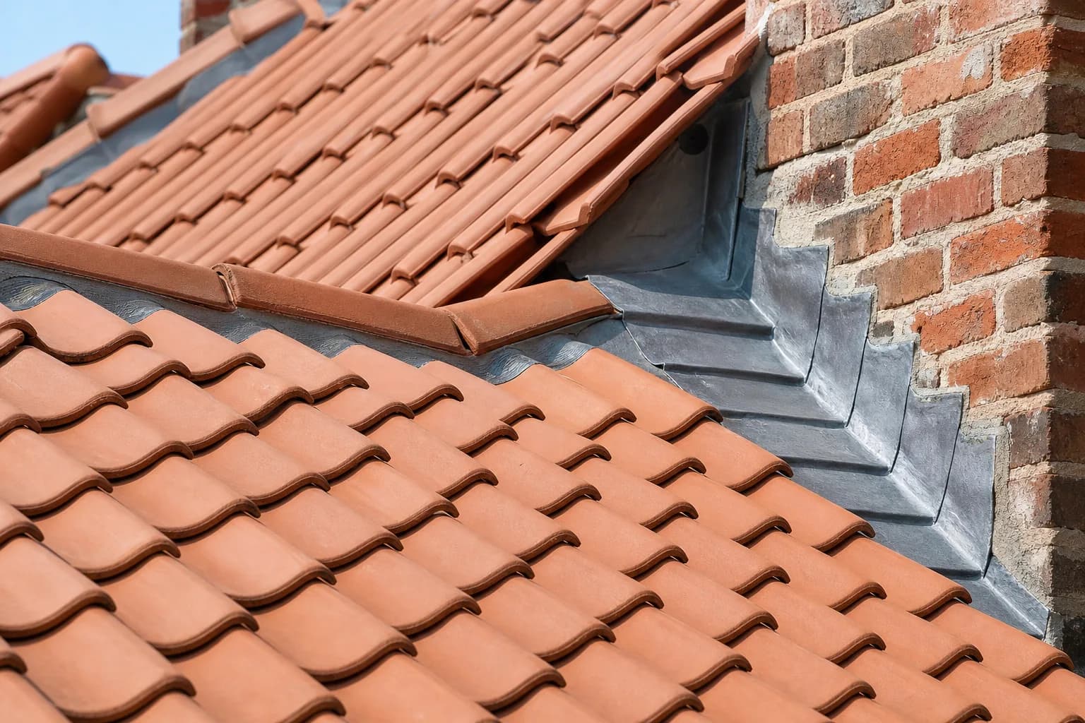 Close-up of neatly laid clay roof tiles with lead flashing